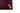 Close up of the Triptych company logo, in gold foil on a dark red background. Logo features two interlocking squares.