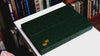 Triptych folio case being opened to reveal a notebook, phone and tablet device inside. Green leather with gold foil embossed onto bottom right corner.